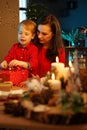 Cheerful mother packing christmas presents with her son