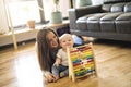 Cheerful mother playing with his baby girl on floor at living room Royalty Free Stock Photo