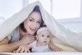 Cheerful mother plays with her baby under a blanket Royalty Free Stock Photo