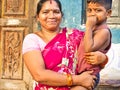 Cheerful mother with red saree with adorable young boy in the street of village. Dalit people so poor but smiling