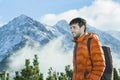 Cheerful mountain guide having rest at astonishing winter rocky landscape background