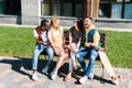 cheerful multicultural couples resting on bench together