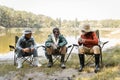 Cheerful multicultural men in fishing outfit