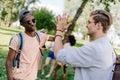 Multiethnic boys giving high five while meeting in park