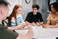 Cheerful multiethnic friends having fun with charades cards play, enjoying board games activity for entertainment at Royalty Free Stock Photo