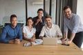 Cheerful multiethnic professional business team posing together at office table Royalty Free Stock Photo