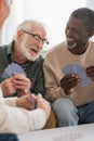 Cheerful multiethnic senior men playing cards Royalty Free Stock Photo