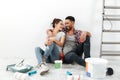 Cheerful multiethnic young couple renovating home and resting