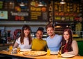 Cheerful multiracial friends having fun eating in pizzeria. Royalty Free Stock Photo