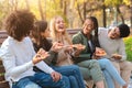 Cheerful multiracial teens laughing while eating pizza