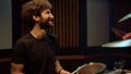 Cheerful musician man laughing in studio. Smiling drummer speaking in hall.