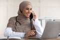 Cheerful muslim lady doctor having conversation on phone with patient Royalty Free Stock Photo