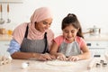 Cheerful Muslim Mother In Hijab Baking With Her Little Daughter In Kitchen