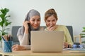 Cheerful muslim woman and her friend watching movies together in their free time