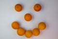 cheerful muzzle made with whole oranges on a white background