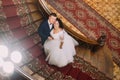 Cheerful newlywed pair posing on wooden stairs. Top view Royalty Free Stock Photo