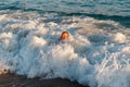 Cheerful nine-year-old boy swims on the waves at sea. only the head out of the water can be seen Royalty Free Stock Photo