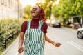 Cheerful non-binary person dancing on the street in the city