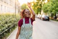 Cheerful non-binary person dancing on the street in the city