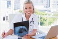 Cheerful nurse holding an x ray in her office Royalty Free Stock Photo