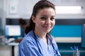Cheerful nurse in office, wearing scrubs Royalty Free Stock Photo