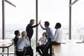 Cheerful office friends giving high fives at business team meeting Royalty Free Stock Photo