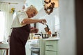 Joyful senior woman in apron cooking dinner in kitchen Royalty Free Stock Photo