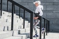 Cheerful old lady training to run up concrete stairs Royalty Free Stock Photo