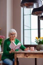 Cheerful old lady writing down vedic books main points Royalty Free Stock Photo