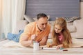 Cheerful old man painting with his granddaughter Royalty Free Stock Photo