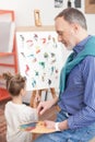 Cheerful old painter and his small grandchild Royalty Free Stock Photo