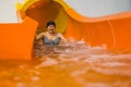 cheerful old woman having a great time on an orange indoor water slide, fun activities for senior people Royalty Free Stock Photo