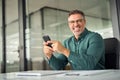 Happy older professional business man using phone at work in office. Portrait. Royalty Free Stock Photo