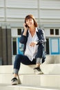 Cheerful older woman sitting on steps with smart phone Royalty Free Stock Photo