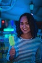 Cheerful optimistic asian girl with neon ice cream