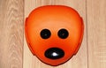 Cheerful orange face of a mouse on a beige floor