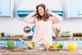 cheerful overweight woman listening music in headphones at table with fresh vegetables in kitchen Royalty Free Stock Photo