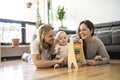 Cheerful parent playing with his baby girl on floor at living room