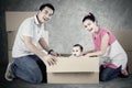 Cheerful parents and child play with box Royalty Free Stock Photo