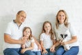 Cheerful parents and cute daughters on sofa in the living room at home. Family with little pet dog Royalty Free Stock Photo
