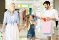 Cheerful Parents Giving Little Daughter A Gift Walking In Mall