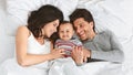 Cheerful parents having fun with their baby boy in bed Royalty Free Stock Photo