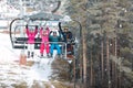 Parents with male and female child in chair lift climb up on ski Royalty Free Stock Photo