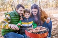 Cheerful parents with son grilling sausages Royalty Free Stock Photo