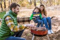 Cheerful parents with son grilling sausages Royalty Free Stock Photo