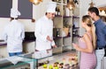 Cheerful pastry man is serving visitors