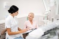 Cheerful patient asking her dentist about procedures.