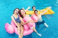 Cheerful people looking at camera in swimming pool