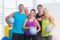 Cheerful people with medicine balls in fitness studio