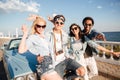 Cheerful people standing and showing peace sign near vintage car Royalty Free Stock Photo